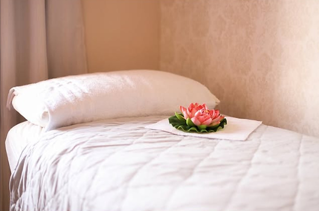 Maca com roupa de cama branca e uma flor de lótus decorativa